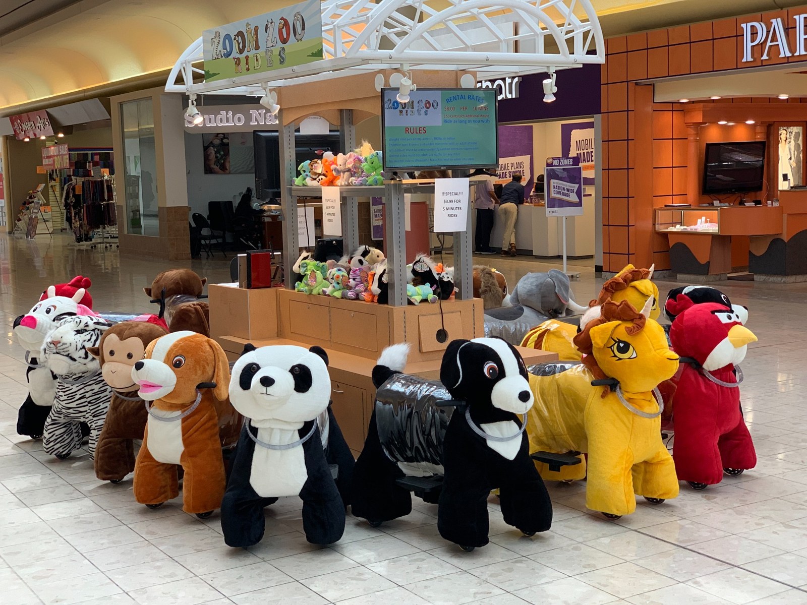 A colorful collection of animal rides lined up inside a mall
